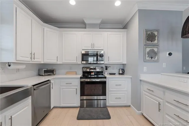 a kitchen with granite countertop white cabinets and stainless steel appliances