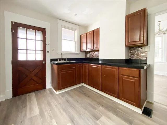 a kitchen with granite countertop wooden cabinets and a sink