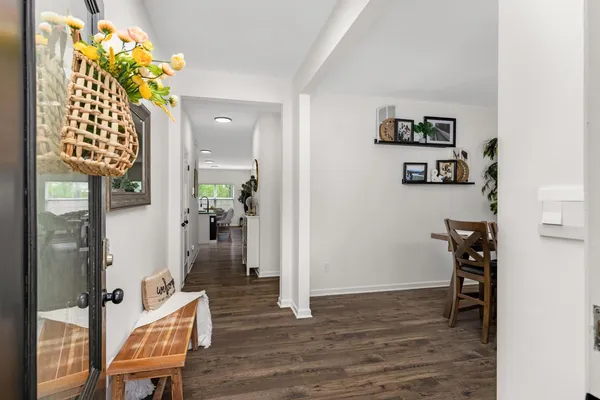 a view of a hallway with wooden floor and a dining room