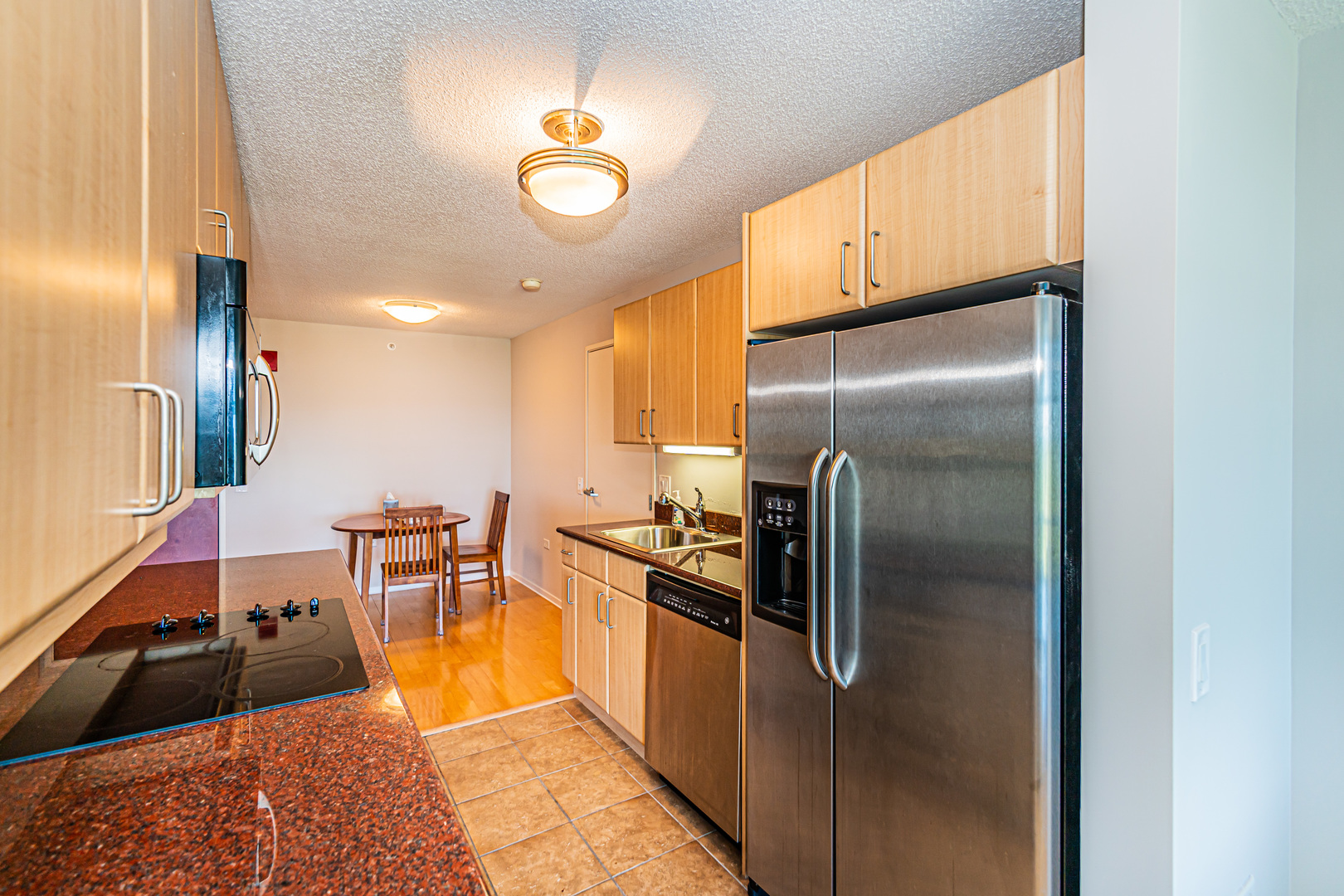 800 Elgin Road, Unit 1005 Evanston, IL 60201 - Photo 3 of 39 a kitchen with stainless steel appliances granite countertop a refrigerator a stove and a sink with wooden floor