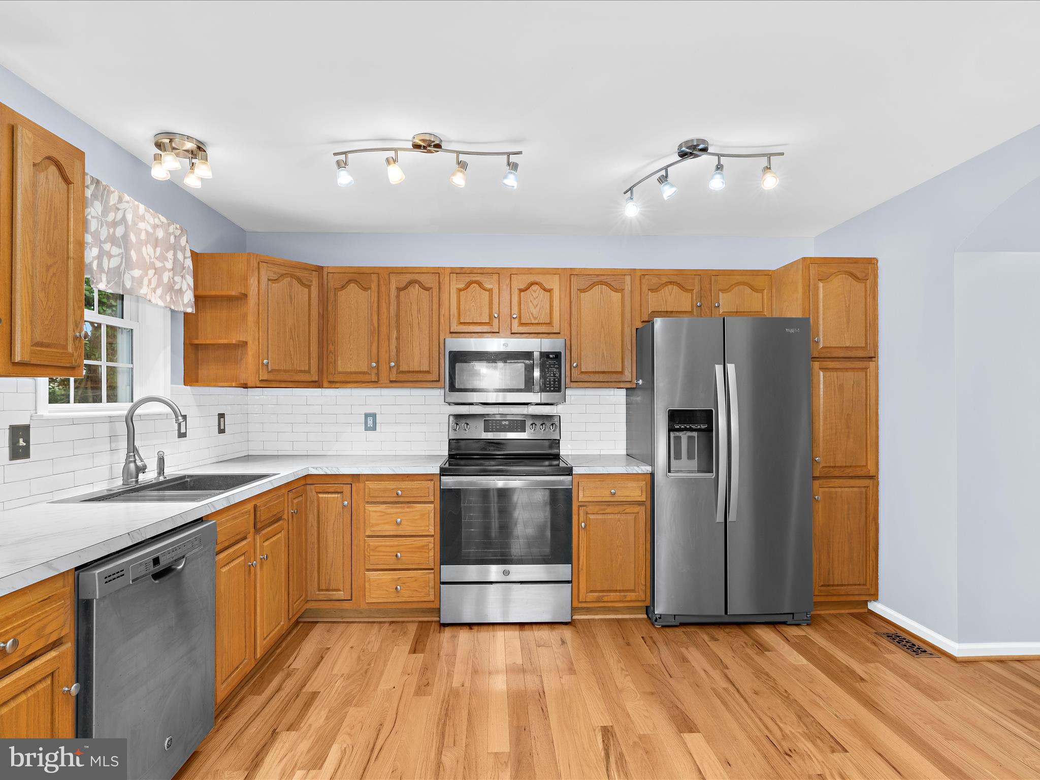 931 Oakleigh Beach Road Baltimore, MD 21222 - Photo 11 of 52 a kitchen with stainless steel appliances granite countertop a sink a stove a refrigerator cabinets and wooden floor