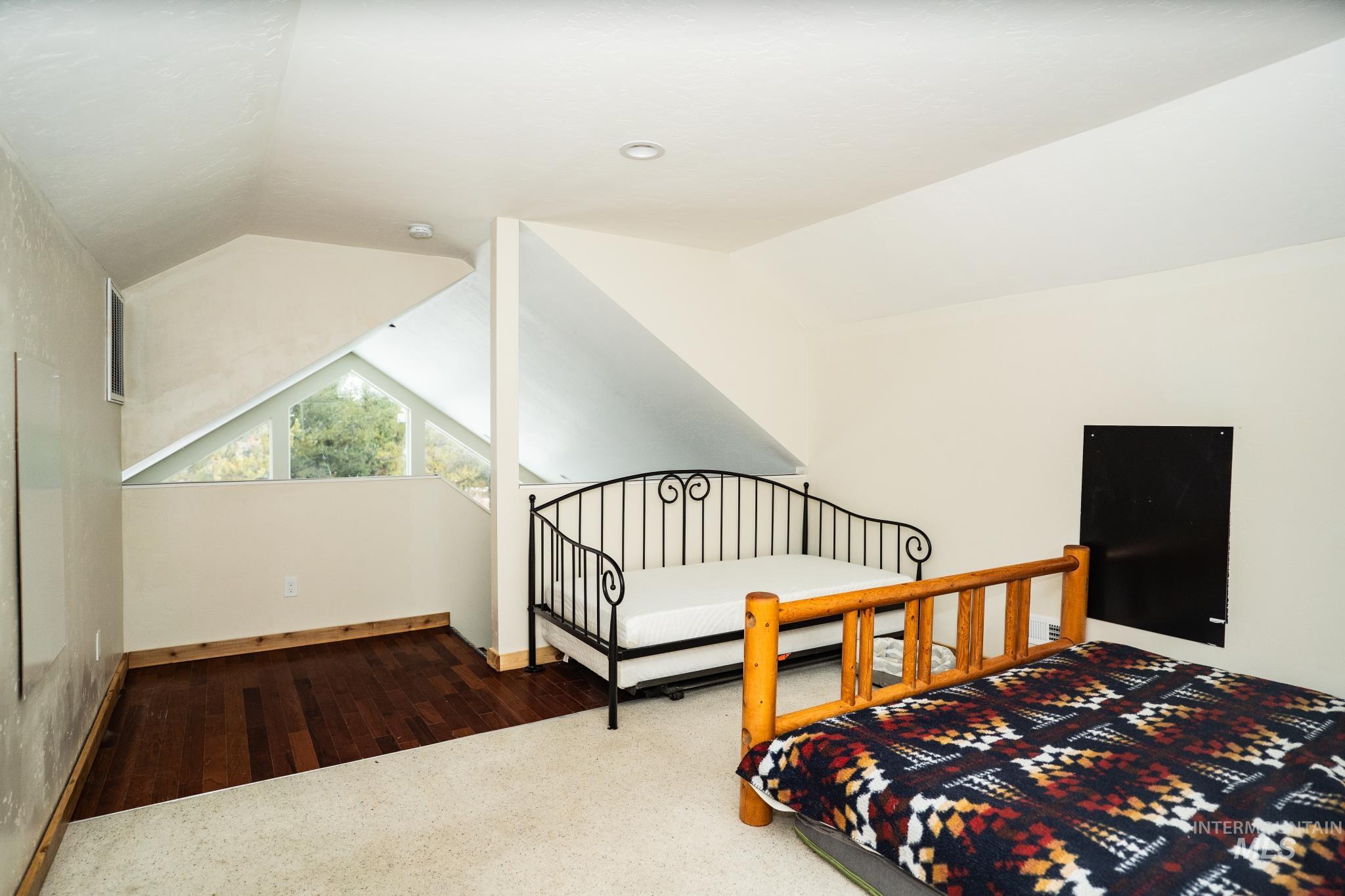22 West Prospectors Drive Cascade, ID 83611 - Photo 10 of 25 Bonus Room featuring lofted ceiling, dark wood-style flooring, and dark colored carpet
