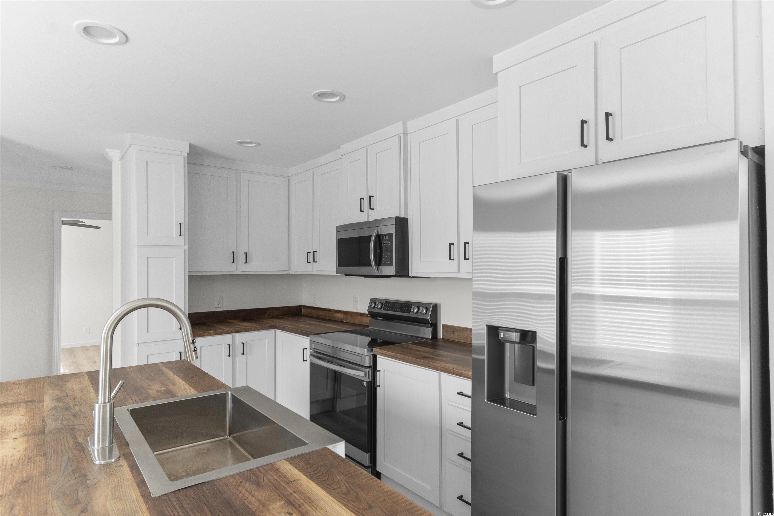 141 Feather Drive Georgetown, SC 29440 - Photo 14 of 34 Kitchen featuring wood counters, stainless steel appliances, white cabinets, wood finished floors, and recessed lighting