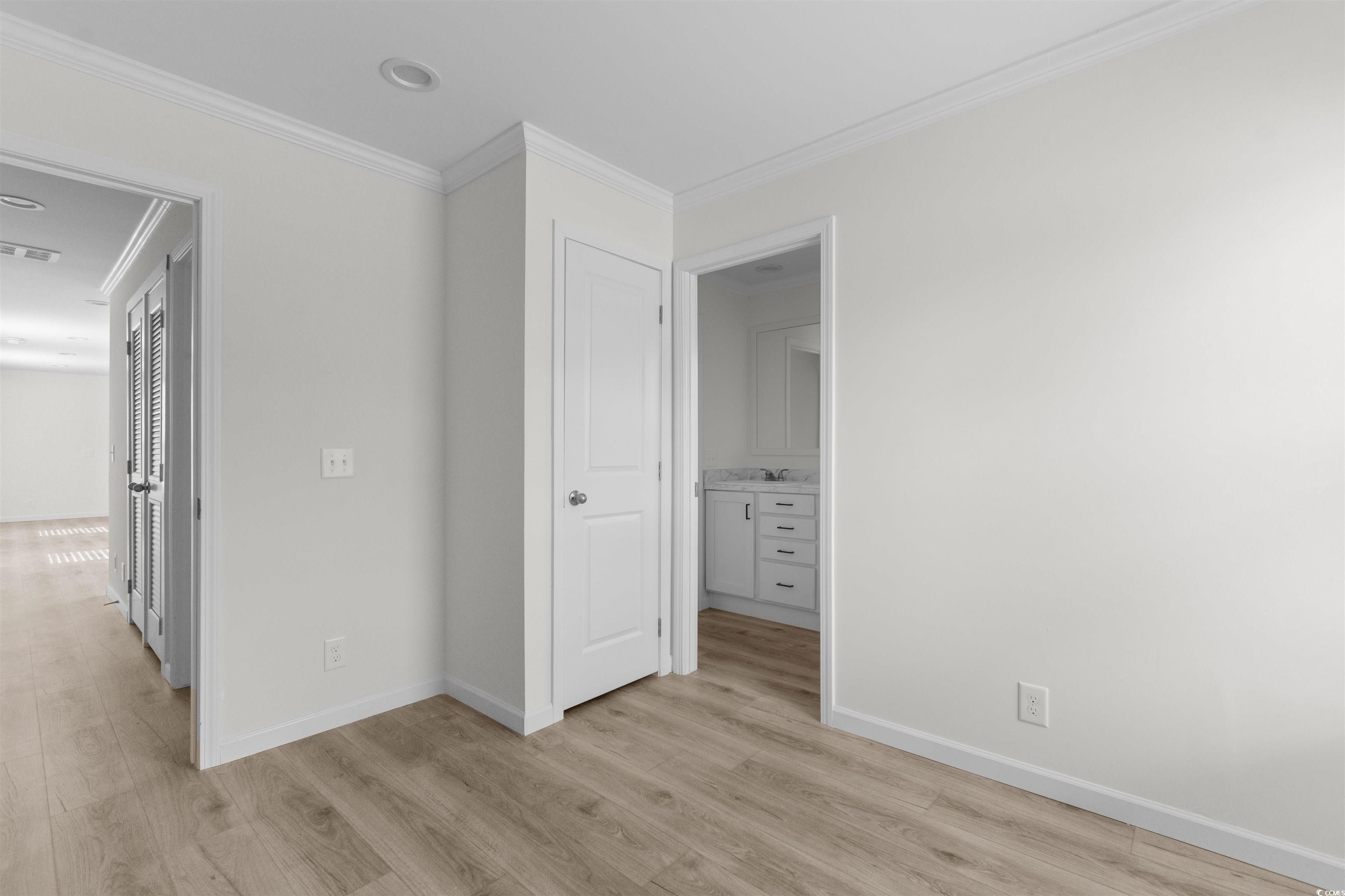 141 Feather Drive Georgetown, SC 29440 - Photo 17 of 34 Unfurnished bedroom featuring light wood-type flooring, crown molding, and ensuite bath