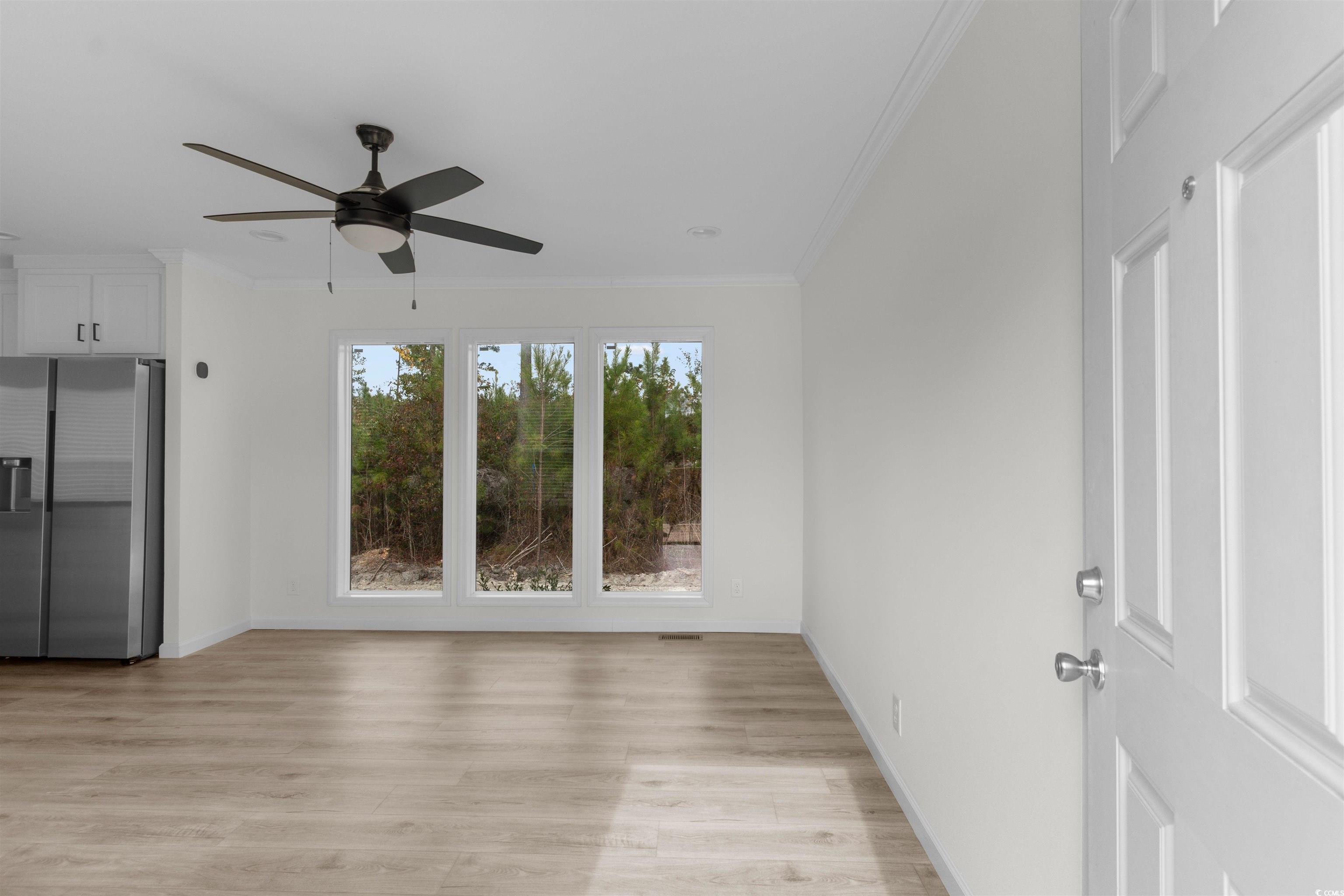 141 Feather Drive Georgetown, SC 29440 - Photo 9 of 34 Spare room with ornamental molding, light wood-type flooring, and ceiling fan