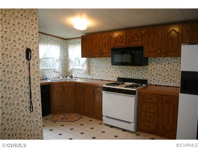4900 Tabscott Road Kents Store, VA 23084 - Photo 4 of 9 a kitchen with granite countertop a stove a sink and a microwave