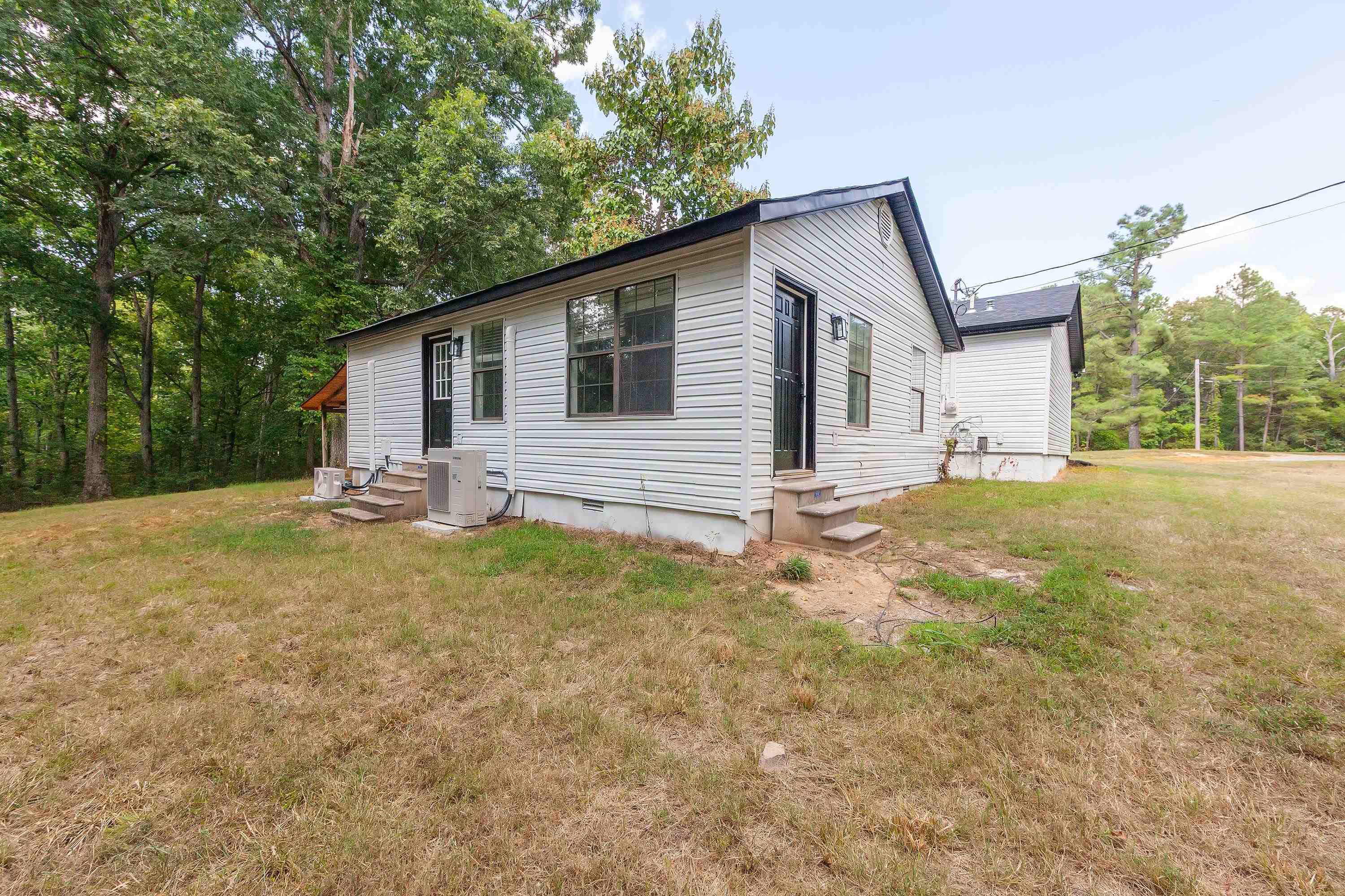 3690 Callahan Road Middleton, TN 38052 - Photo 22 of 26 White siding exterior with black trim, multiple windows, and exterior doors