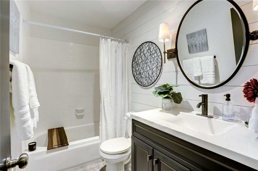 8210 Bent Tree Road, Unit 136 Austin, TX 78759 - Photo 11 of 20 Full bathroom featuring vanity, shower / bath combo with shower curtain, and wooden walls