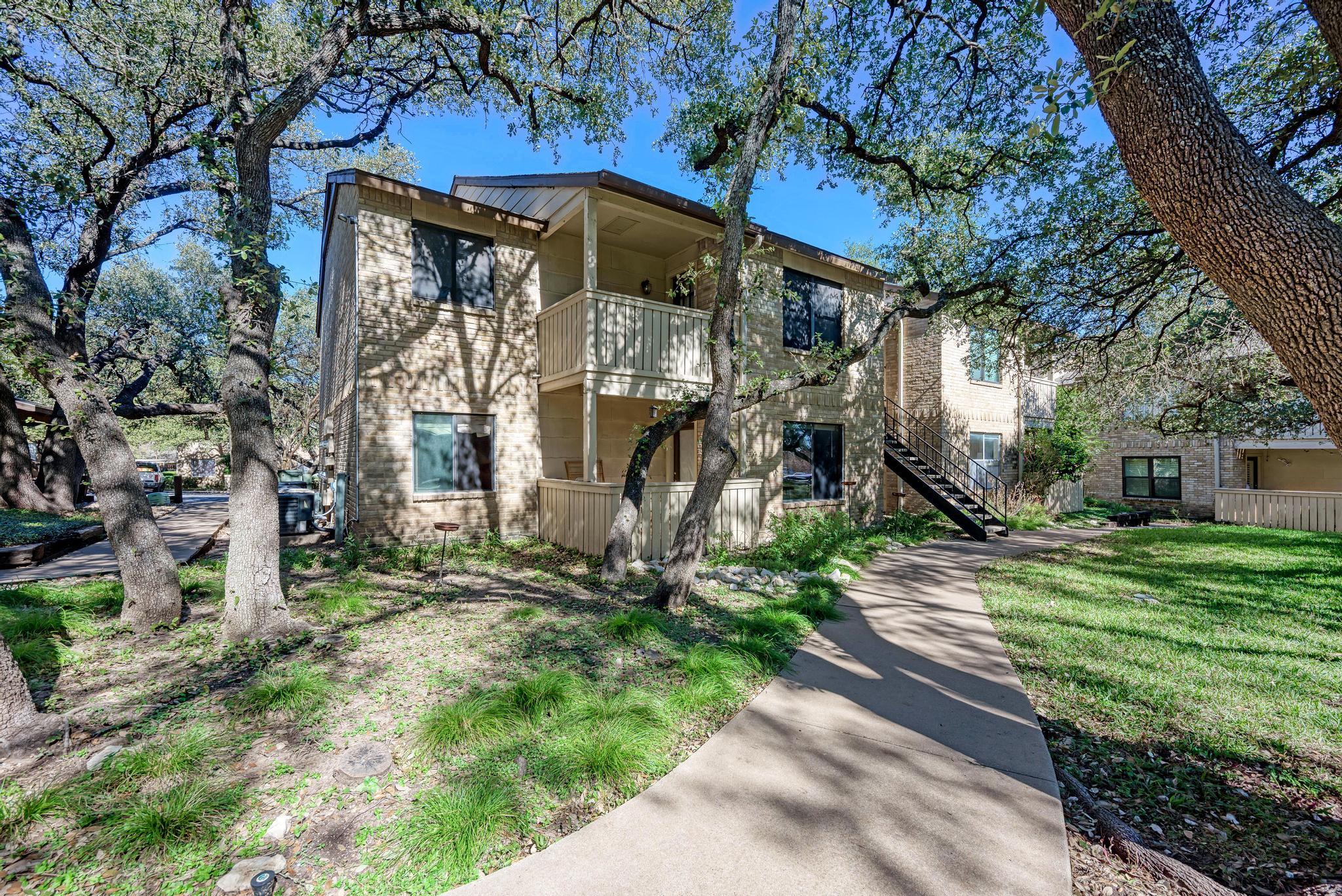 8210 Bent Tree Road, Unit 136 Austin, TX 78759 - Photo 20 of 20 View of front facade featuring a balcony, stairway, and brick siding