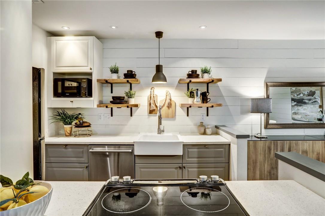 8210 Bent Tree Road, Unit 136 Austin, TX 78759 - Photo 5 of 20 Kitchen with black appliances, open shelves, light stone countertops, gray cabinetry, and pendant lighting