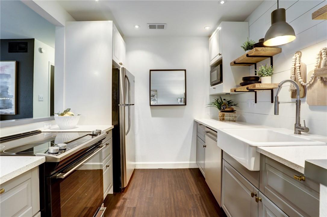 8210 Bent Tree Road, Unit 136 Austin, TX 78759 - Photo 6 of 20 Kitchen featuring stainless steel appliances, open shelves, light stone counters, white cabinetry, and recessed lighting
