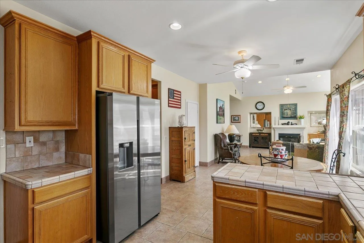 13669 Acorn Circle Valley Center, CA 92082 - Photo 14 of 33 a kitchen with a refrigerator a sink dishwasher with a dining table and chairs