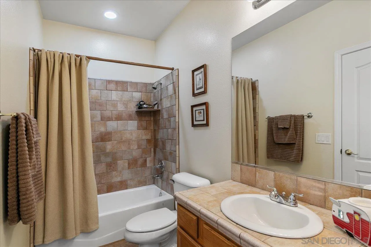 13669 Acorn Circle Valley Center, CA 92082 - Photo 30 of 33 a bathroom with a granite countertop sink toilet and shower