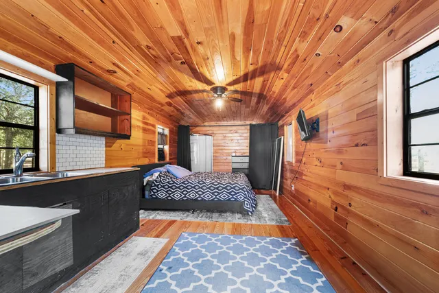 a spacious bedroom with a bed and a flat screen tv