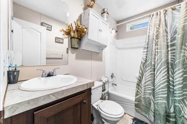 a spacious bedroom with a bed and dresser with mirror