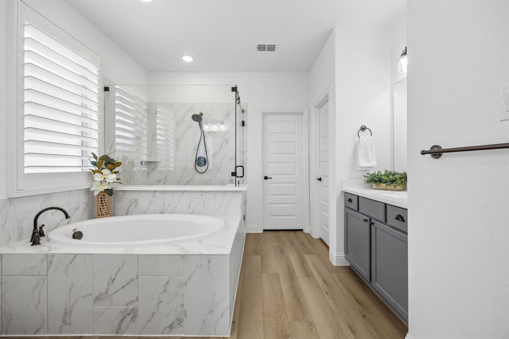 3200 Willowbrook Road Northlake, TX 76226 - Photo 16 of 29 Spa-inspired bathroom featuring a built-in soaking tub with marble-look tile surround and a separate glass-enclosed shower with matching tile