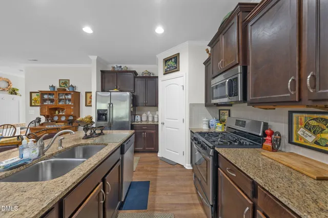 a kitchen with stainless steel appliances granite countertop a sink stove and refrigerator