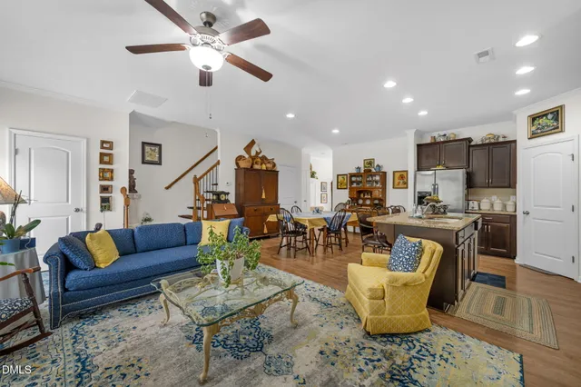 a living room with furniture kitchen view and a chandelier