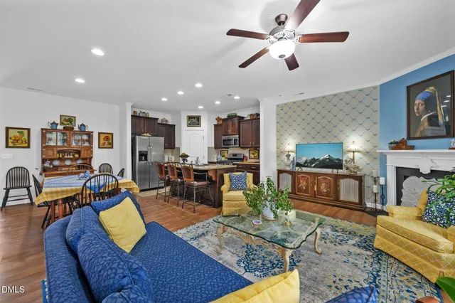 a living room with furniture kitchen view and a chandelier