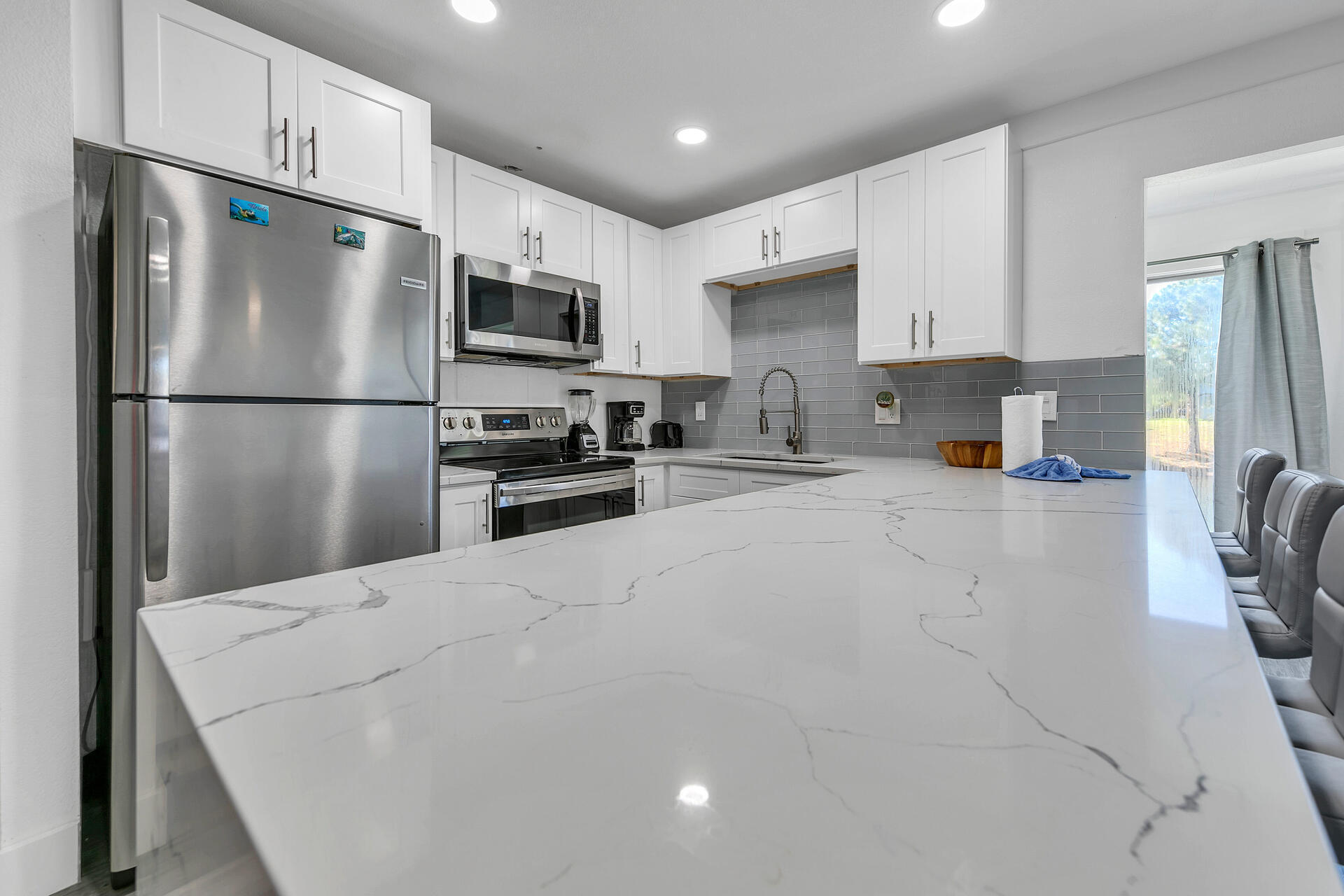 Undisclosed Address Destin, FL 32541 - Photo 12 of 23 a kitchen with stainless steel appliances a refrigerator sink and microwave