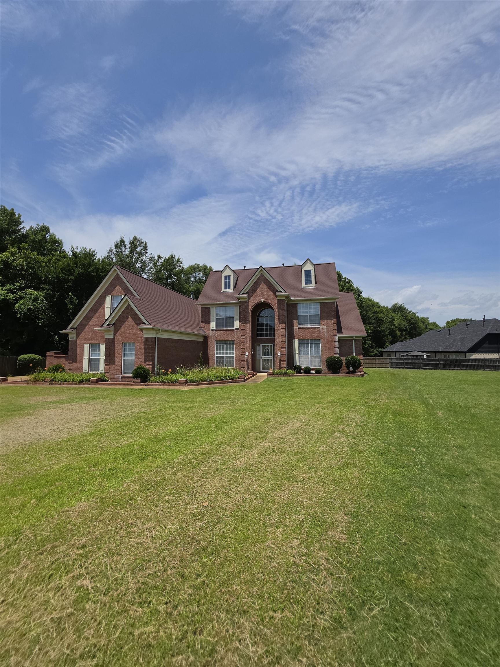 7253 Rourke Circle Memphis, TN 38125 - Photo 31 of 31 Brick facade residence with a prominent arched entry, dormer windows, and a brown roof
