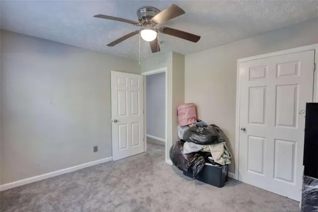 a bedroom with a bed and a chandelier fan