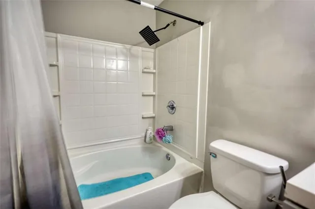 a bathroom with a toilet and a shower