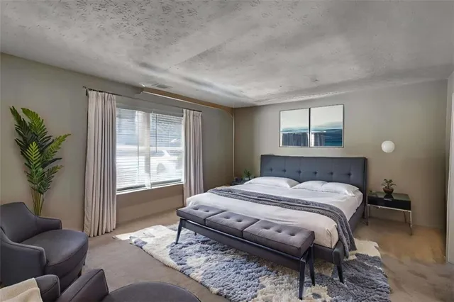 a bedroom with a bed couch and a window