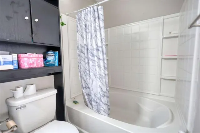 a bathroom with a sink a toilet and shower curtain