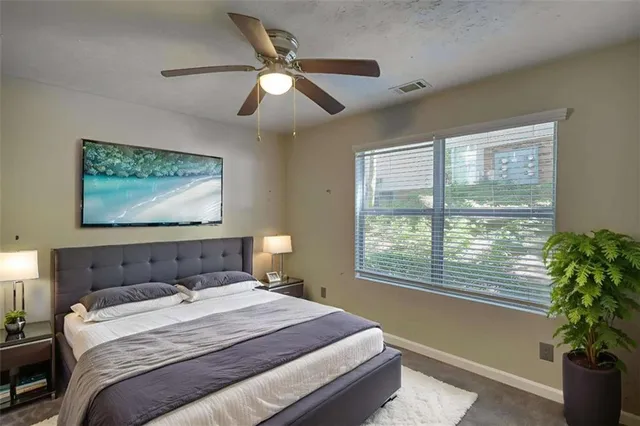 a bedroom with a large bed and a potted plant