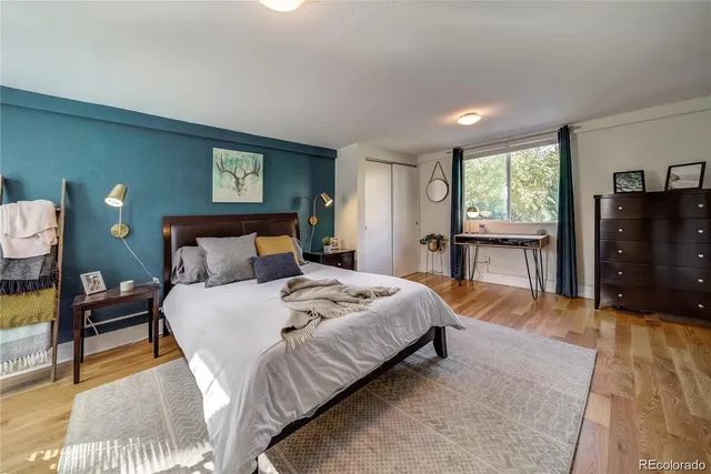 a bedroom with a bed and wooden floor