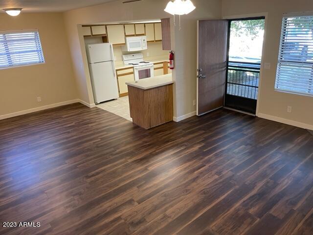 1444 North Recker Road, Unit 167 Mesa, AZ 85205 - Photo 4 of 13 a kitchen with granite countertop wooden floors and stainless steel appliances