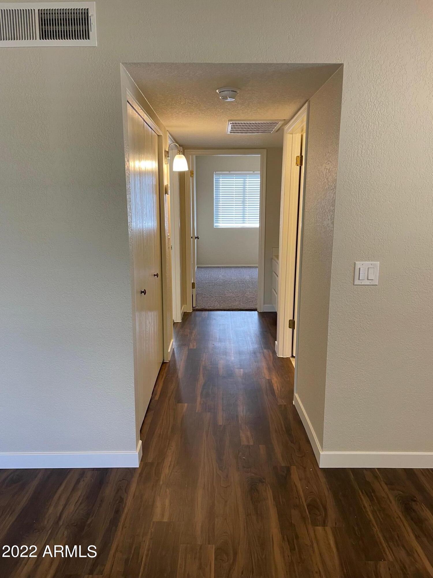 1444 North Recker Road, Unit 167 Mesa, AZ 85205 - Photo 5 of 13 a view of a hallway with wooden floor
