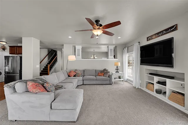 a living room with furniture and kitchen view