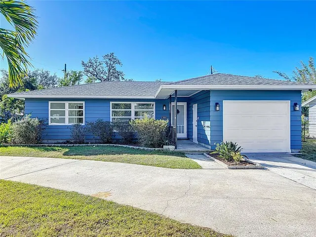 a front view of a house with a yard and potted plants