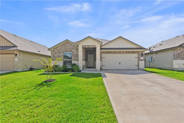 a front view of a house with a yard and garage