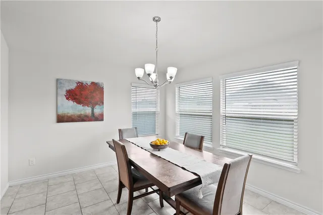 a view of a dining room with furniture a chandelier and wooden floor