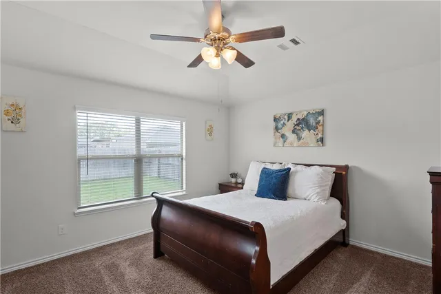a bedroom with a large bed and a window