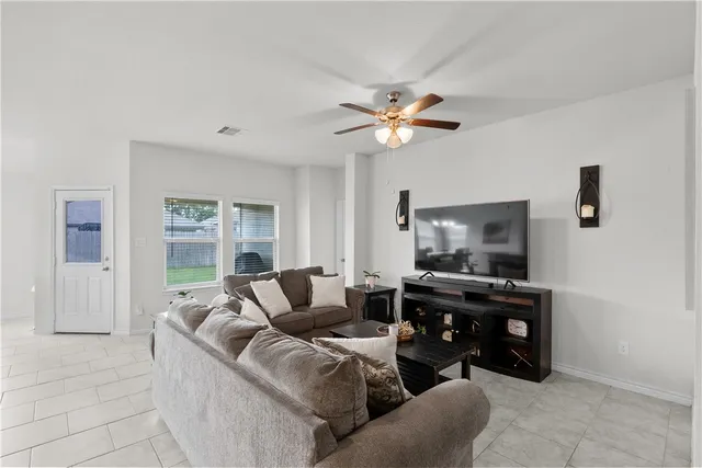 a living room with furniture kitchen view and a chandelier