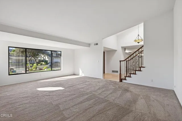 a view of a hallway with wooden floor and a chandelier