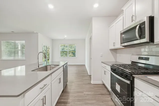 a kitchen with stainless steel appliances a stove microwave and cabinets