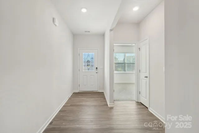 an empty room with wooden floor & windows and bathroom