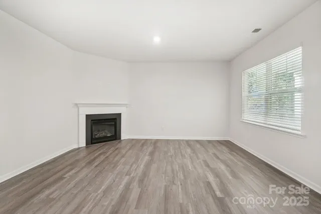 wooden floor in an empty room with a fireplace