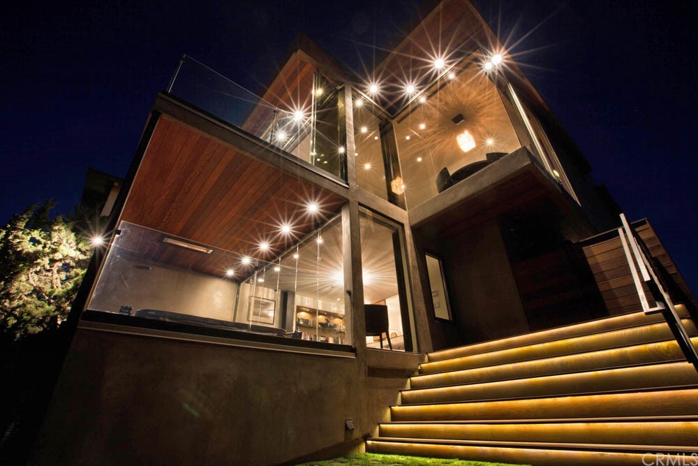 a view of staircase with railing and pendant lights