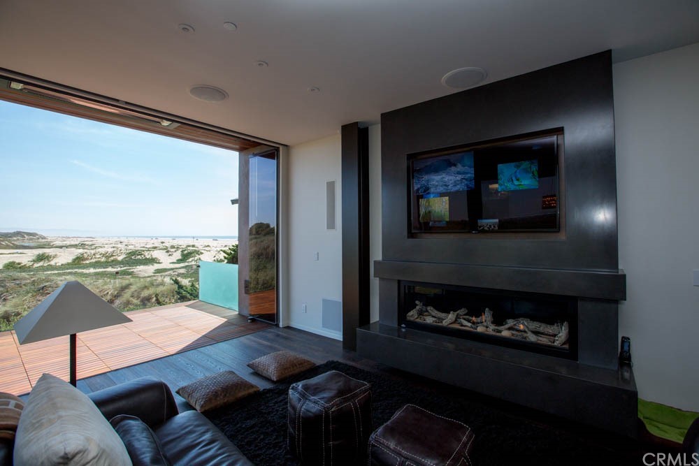 1839 Strand Way Oceano, CA 93445 - Photo 24 of 47 a living room with furniture a floor to ceiling window and a fireplace