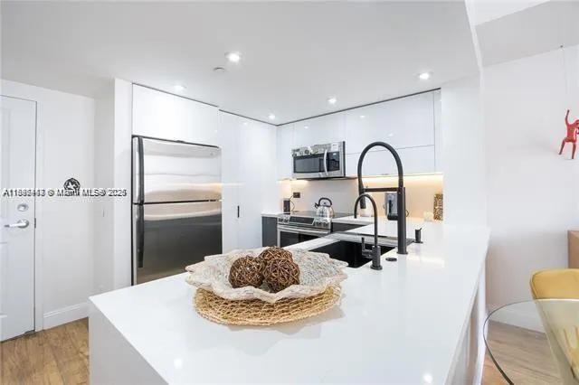 a kitchen with a refrigerator and a stove top oven