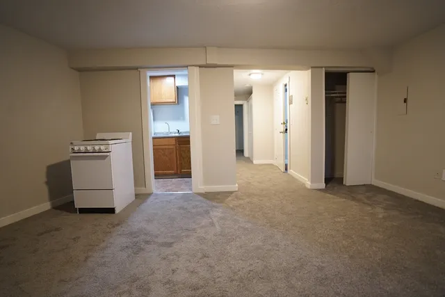 a view of an empty room with a kitchen