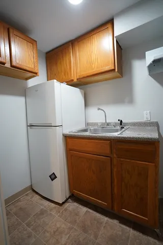 a kitchen with sink a refrigerator and cabinets