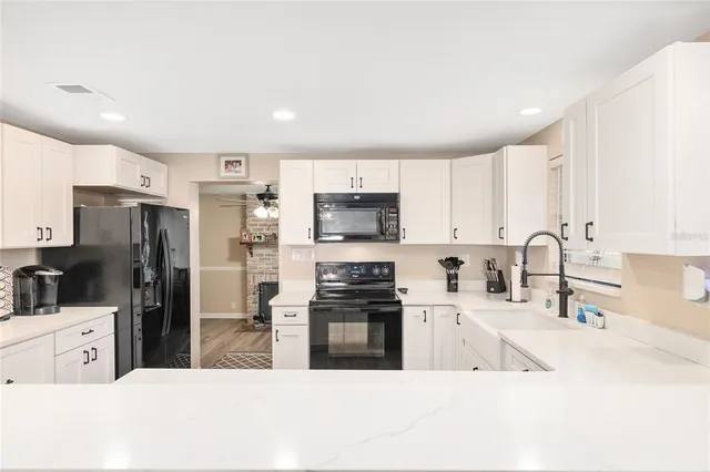 a kitchen with counter top space a sink wooden floor and stainless steel appliances