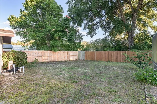 a view of a house with backyard and trees